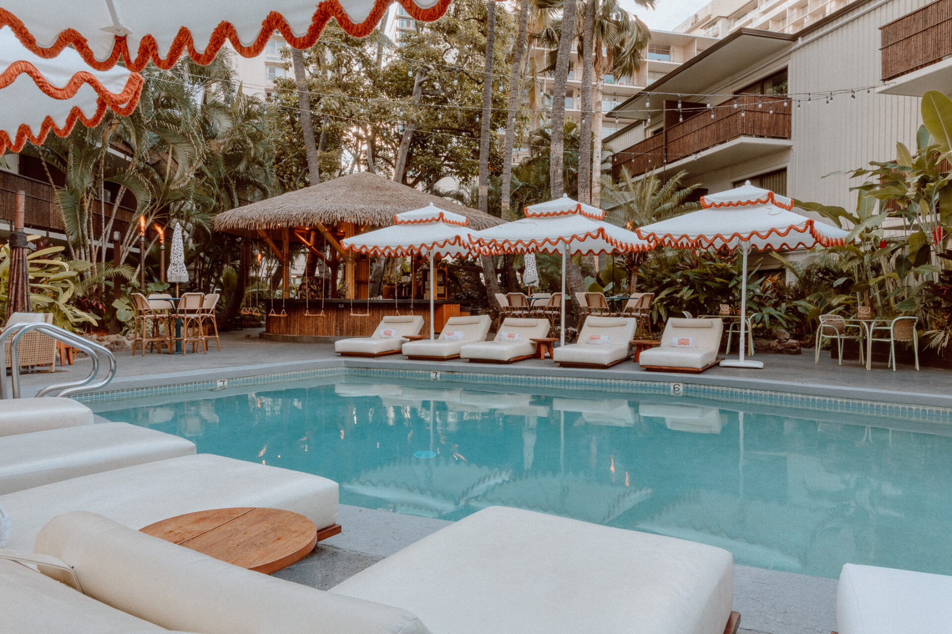 Poolside view of Heyday bar at White Sands Hotel in Waikiki, featuring vintage-style seating and tropical surroundings