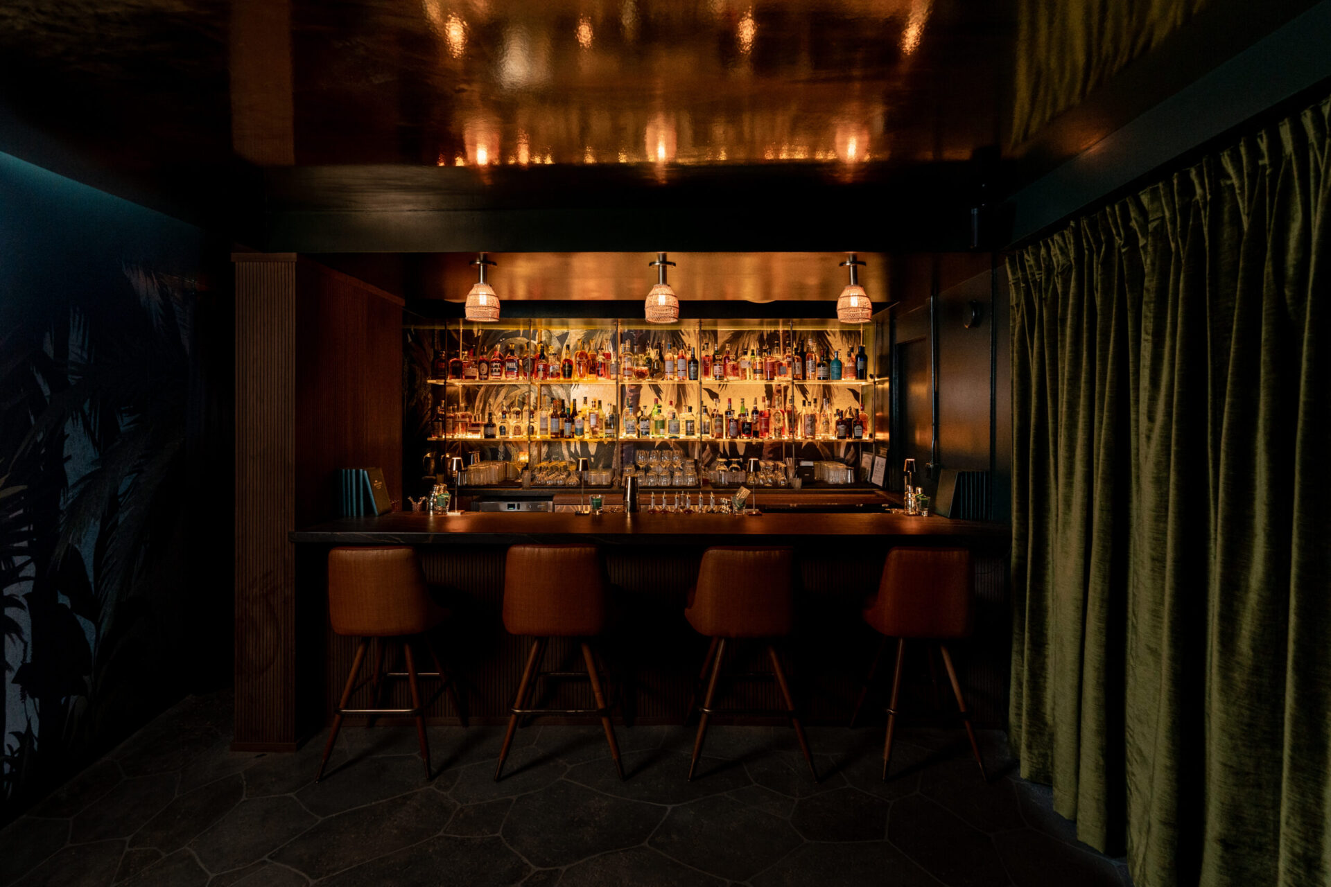 Green Lady lounge at White Sands Hotel with emerald seating and brass accents in Waikiki