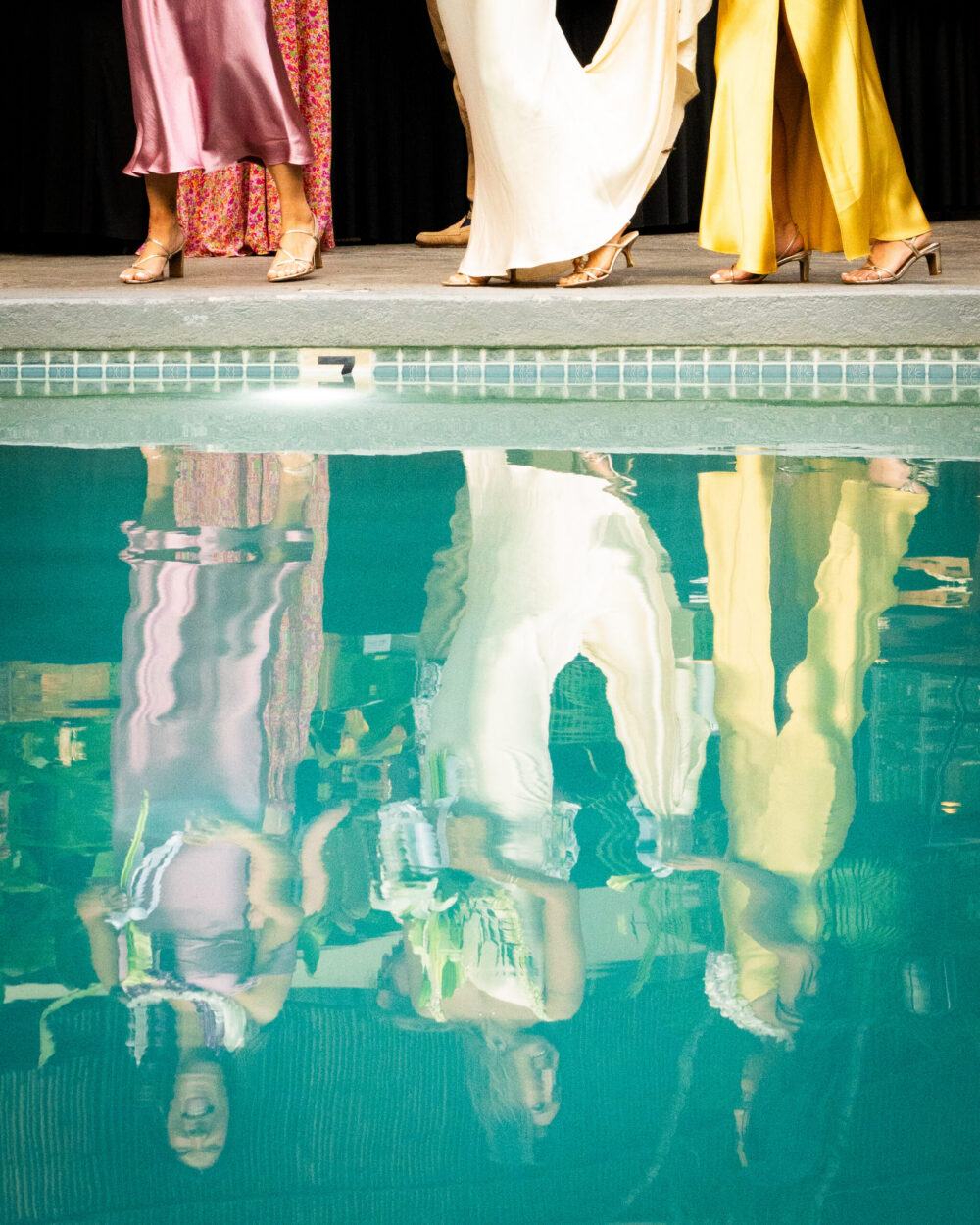 a pool with people's legs reflected in the water